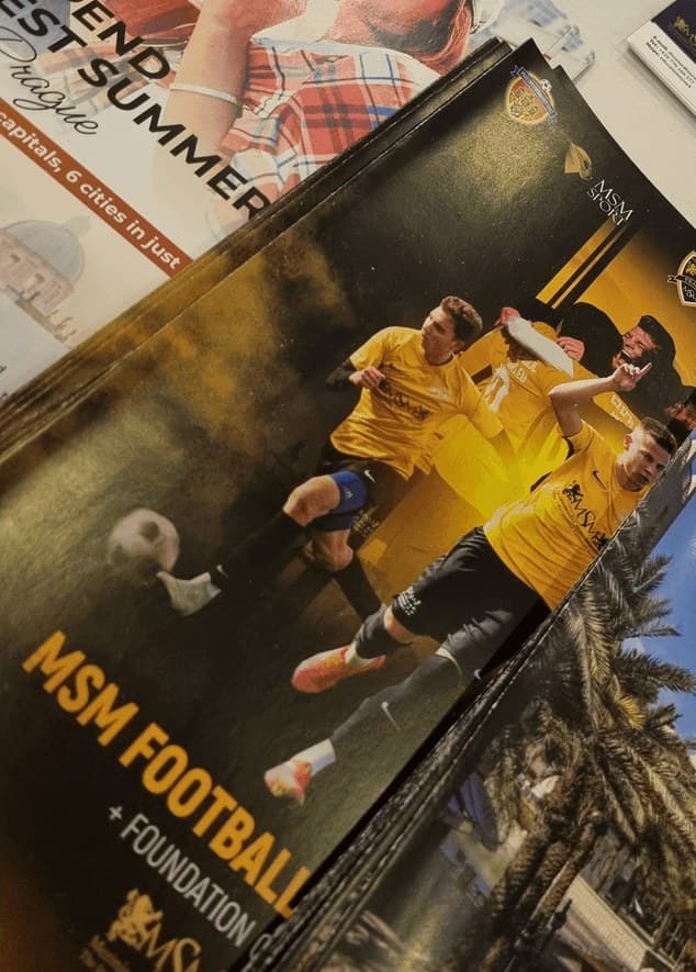 Printed MSM Football brochure on a table at an education fair